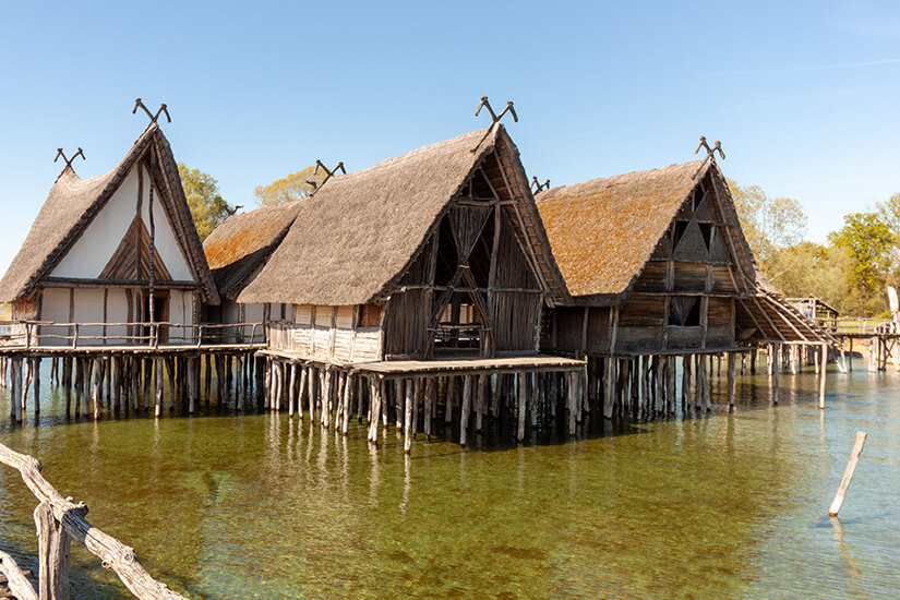 Mehrere Pfahlbauten ragen aus dem Wasser des Bodensees auf. Ueberlingen Deutschland Pfahlbauten