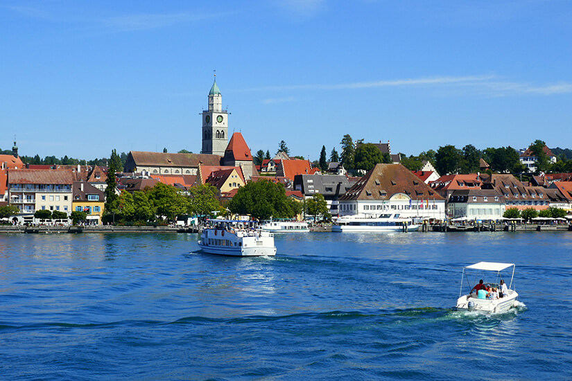 Ein Schiff und ein Tretboot fahren vor Überlingens Ufer über den Bodensee. Ueberlingen Deutschland Bodensee