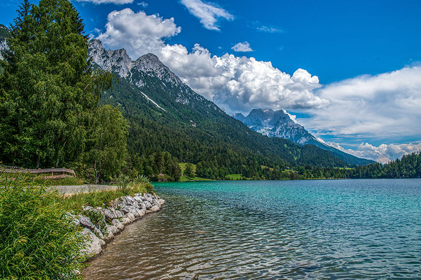 Der türkis schimmernde Hintersteiner See liegt eingebettet zwischen dichten Wäldern und den schroffen Gipfeln des Wilden Kaisers. Das kristallklare Gewässer zählt zu den saubersten Badeseen in ganz Österreich. Wörgl Österreich See