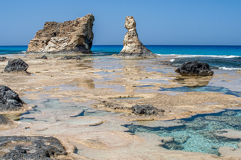 Bizarre Felsformationen ragen aus den natürlichen Gezeitenpools am Cleopatra Beach bei Marsa Matrouh. Das kristallklare Wasser schimmert in verschiedenen Blautönen zwischen den Kalksteinsäulen. Ägypten Strände Cleopatra Beach