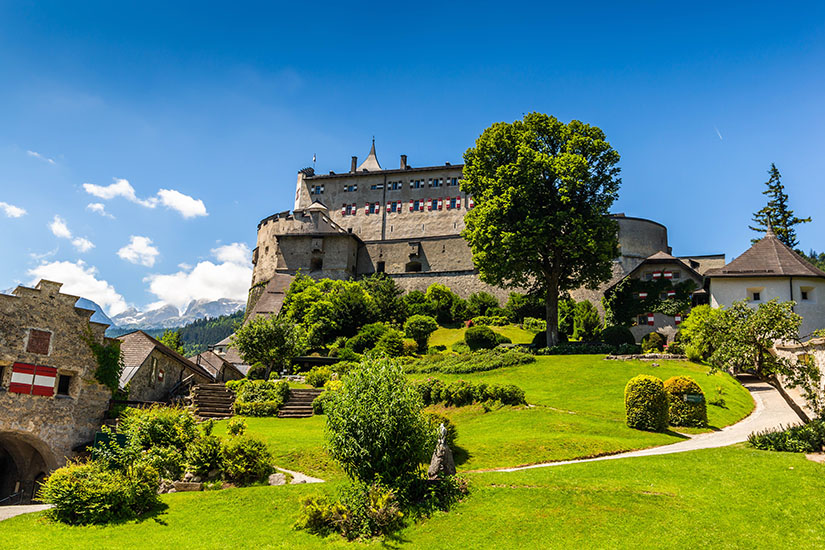 Auf einer bewachsenen Anhöhe thront die mittelalterliche Festung Hohenwerfen mit mächtigen Rundtürmen, Wehrmauern und rot-weißen Fensterläden. Bischofshofen Burg Hohenwerfen