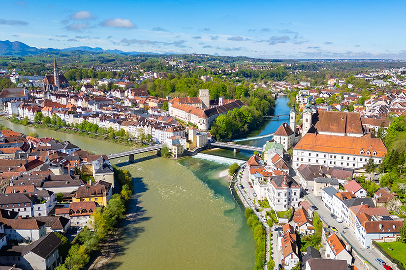 Brücken verbinden verschiedene Stadtteile von Steyr. Zwei Flüsse führen vorbei an weißen Häusern mit roten Dächern und grüner Landschaft. Steyr Oesterreich Zwischenbruecken