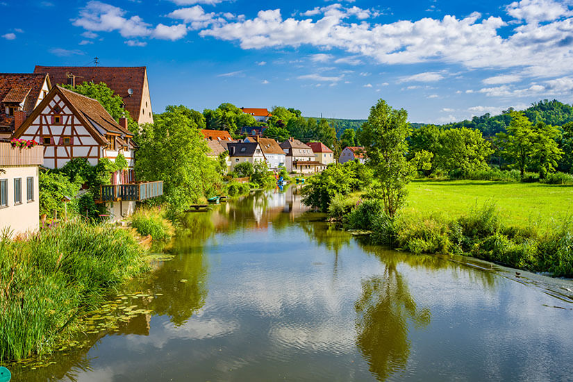 Die Wörnitz führt durch malerische Dörfer und grüne Landschaft. Dinkelsbuehl Deutschland Fluss