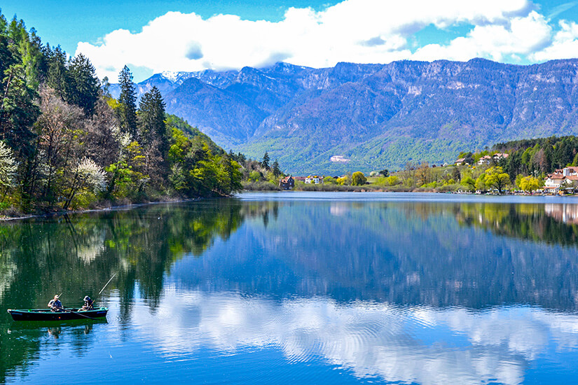 Der Große Montiggler See ist voneinem Panorama aus Bergen umgeben. Tirol Badeseen grosser Montiggler