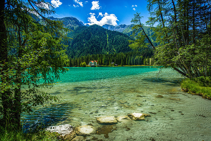 Der Antholzer See beginnt flach und geht in türkisfarbenes Wasser über Tirol Badeseen Antholzer